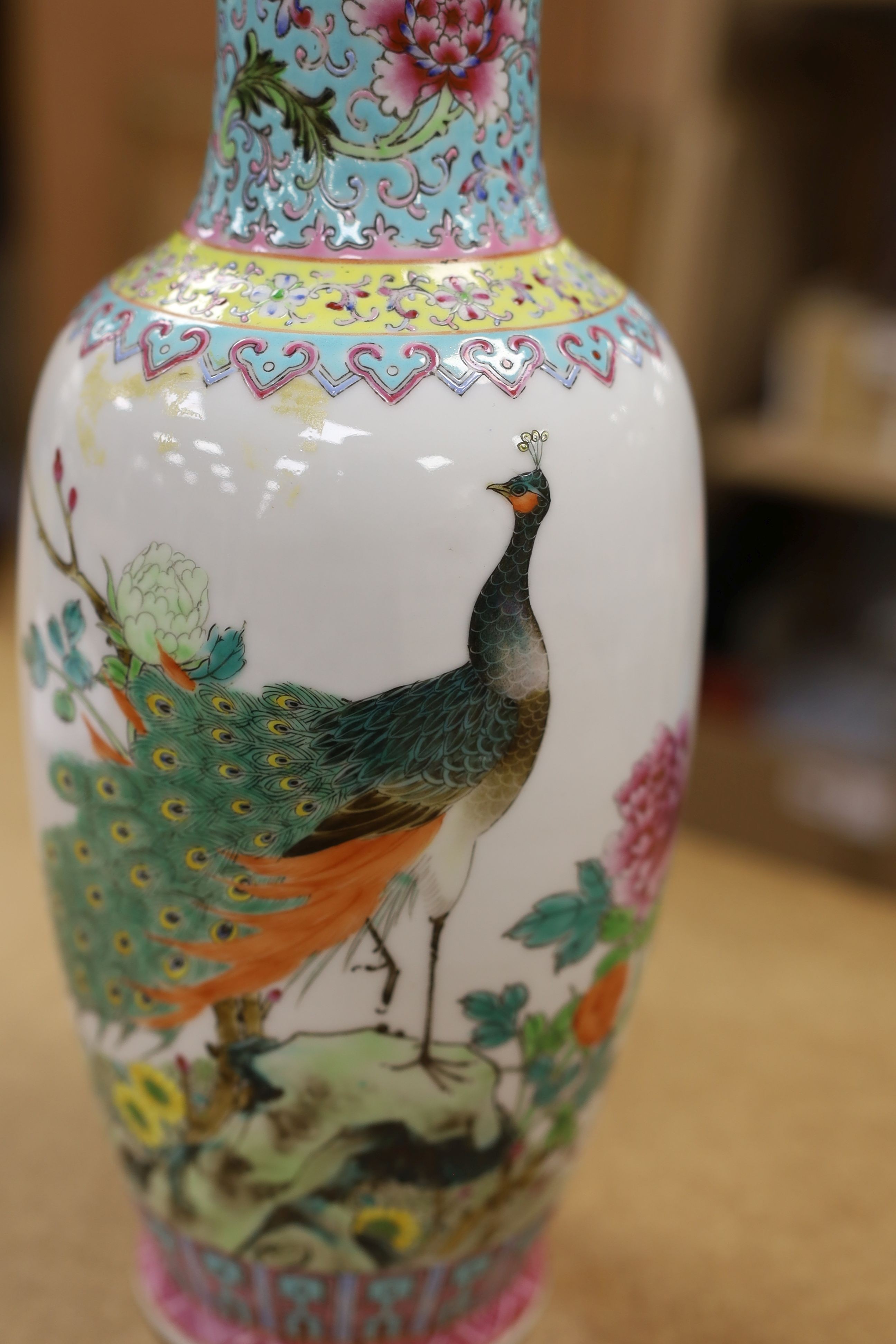 A pair of Chinese famille rose vases decorated with peacocks, 31cm